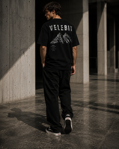 Model wearing ZeroCore Velebit t-shirt in a minimalist outdoor editorial setting